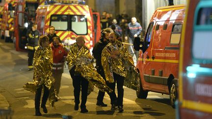 Des rescapés sont évacués du Bataclan après&nbsp;l'attentat, vendredi 13 novembre 2015 à Paris. (MIGUEL MEDINA / AFP)