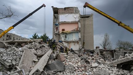 Des secouristes en pleines recherches dans les décombres autour d'un complexe d'appartements touché par une frappe russe à Tchassiv Iar, dans l'est de l'Ukraine, le 10 juillet 2022.&nbsp; (MIGUEL MEDINA / AFP)