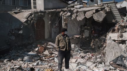 Un homme se tient devant un bâtiment effondré à Antakya, dans le sud de la Turquie, le 13 février 2023. (HIROTO SEKIGUCHI / YOMIURI / AFP)