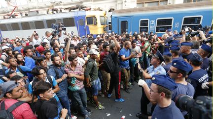 Des migrants et des policiers se font face &agrave; la gare de Budapest (Hongrie), mardi 1er septembre 2015, alors que les premiers tentaient de monter &agrave; bord d'un train pour l'Autriche. (LASZLO BALOGH / REUTERS)