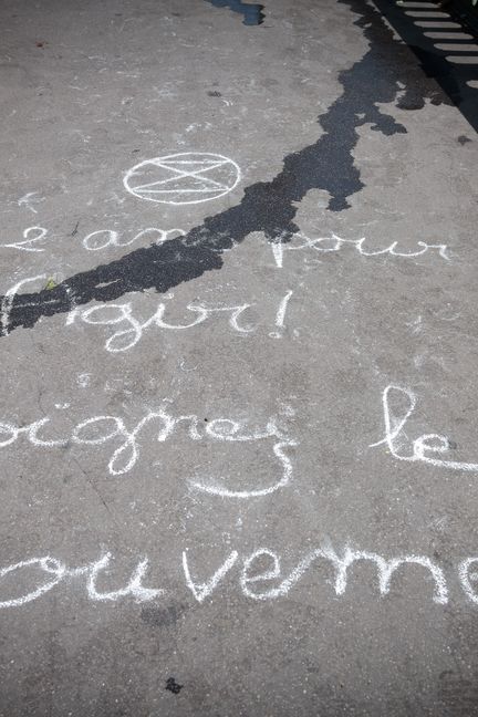 Une invitation à rejoindre&nbsp;Extinction Rebellion tracée à la craie sur le pont de Sully à Paris, le 28 juin 2019. (VINCENT LOISON / SIPA)