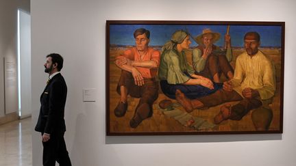 Un employé du musée Thyssen-Bornemisza à Madrid devant une toile d'Olesksandr Syrotenko. Le musée organise une exposition baptisée "In the Eye of the Storm",  sur l'art d'avant-garde ukrainien au début du 20e siècle. (OSCAR DEL POZO / AFP)