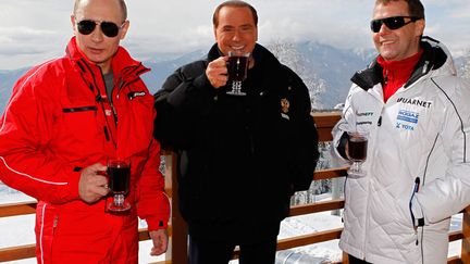 Le pr&eacute;sident russe sortant, Dimitri Medvedev (D), et le nouveau, Vladimir Poutine (G), entourent l'ancien du pr&eacute;sident du Conseil italien, Silvio Berlusconi, dans un chalet &agrave; Krasnaya Polyana (Russie), le 8 mars 2012. (DMITRY ASTAKHOV / AFP)