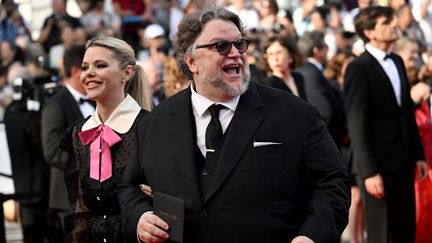 Le réalisateur mexicain Guillermo del Toro rit aux éclats en montant les marches du festival, accompagné de la scénariste&nbsp;Kim Morgan. (LOIC VENANCE / AFP)