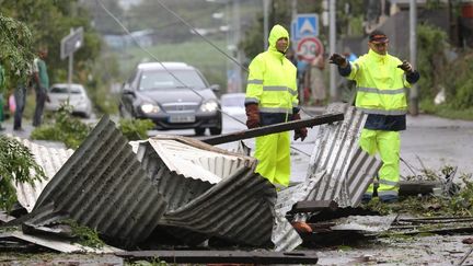 Des hommes nettoyent les rues apr&egrave;s le passage du cyclone Bejisa, vendredi 3 janvier 2014, &agrave; Saint-Pierre (La R&eacute;union). (RICHARD BOUHET / AFP)