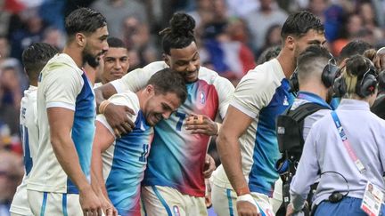 Antoine Dupont et ses coéquipiers célèbrent leur victoire face aux Fidji, le 27 juillet 2024, en finale du tournoi olympique de rugby à 7. (CARL DE SOUZA / AFP)