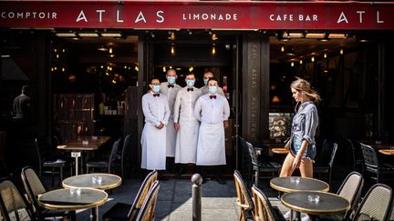 Des serveurs d'un restaurant parisien devant leur établissement, en juin 2020. (MARTIN BUREAU / AFP)