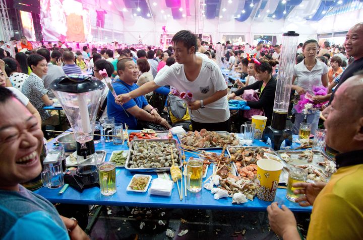 Des festivaliers mangent des fruits de mer lors de la 24e Oktoberfest de Qingdao, en Chine, le 16 ao&ucirc;t 2014.&nbsp; (FRISO GENTSCH / DPA / AFP)