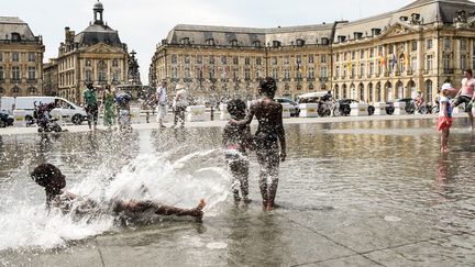 Des enfants jouent sur le "Miroir d'eau", dans le centre de Bordeaux (Gironde), le 27 mai 2017. (MEHDI FEDOUACH / AFP)