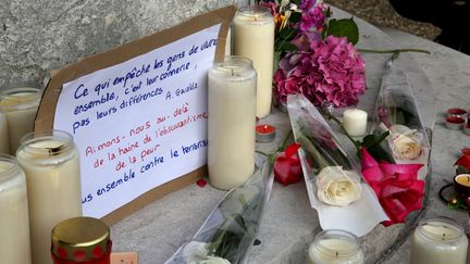 Quelques petits bouquets ont été déposés, ainsi que des messages. "Aimons-nous au-delà de la haine, de l'obscurantisme, de la peur", indique notamment celui-ci. (MAXPPP)