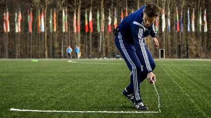 L'arbitre allemand Felix Brych essaie un spray de mousse destin&eacute; &agrave; marquer la ligne derri&egrave;re laquelle doivent se ranger les d&eacute;fenseurs sur un coup franc adverse, le 27 mars 2014 &agrave; Zurich (Suisse). (FABRICE COFFRINI / AFP)