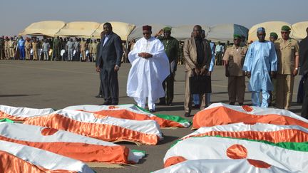 Le président du nigérien&nbsp;Mahamadou Issoufou, le 13 décembre 2019, devant les corps des militaires tués dans une attaque contre un camp militaire à Inates (ouest du Niger), trois jours avant.&nbsp; (BOUREIMA HAMA / AFP)