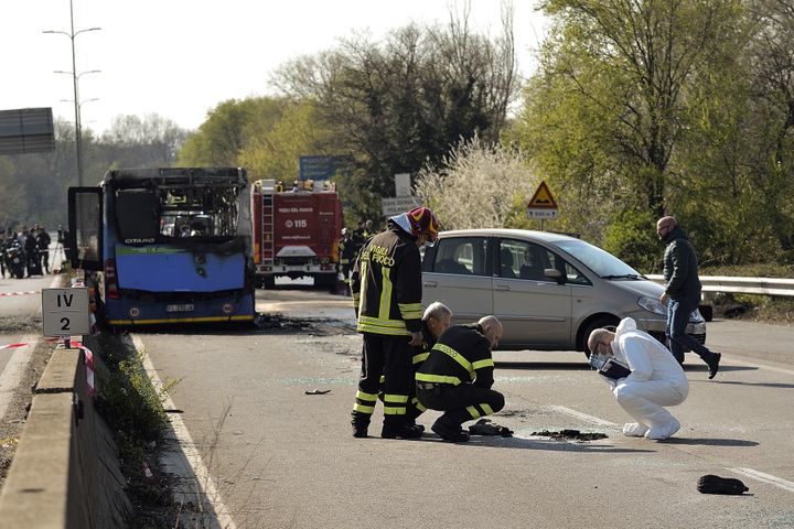 Les enquêteurs examinent les restes calciné du bus, mercredi 20 mars à San Donato (Italie).&nbsp; (FLAVIO LO SCALZO / AFP)