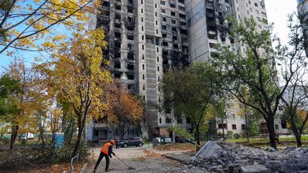 Un homme se tient devant un bâtiment détruit par les bombardements des forces russes, à Kharkiv (Ukraine), le 19 octobre 2022.&nbsp; (VYACHESLAV MADIYEVSKYI / NURPHOTO / AFP)