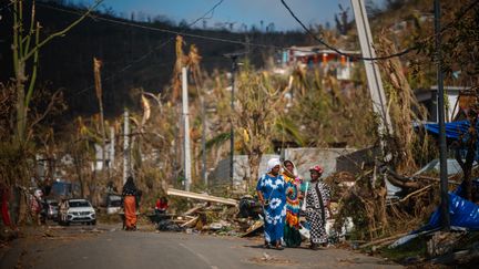 Des femmes dans une rue dévastée à Pamandzi (Mayotte) le 17 décembre 2024, deux jours après le passage du cyclone Chido. (DIMITAR DILKOFF / AFP)