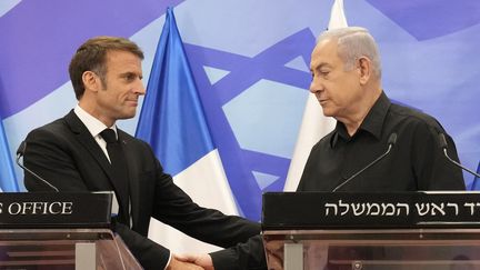 Emmanuel Macron (à gauche) sert la main Premier ministre israélien Benjamin Netanyahu (à droite), lors d'une conférence de presse à Jérusalem, le 24 octobre 2023. (CHRISTOPHE ENA / POOL / MAXPPP)