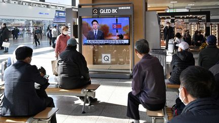 Des habitants de Séoul regardent la télévision qui rapporte le nouveau tir d'un missile nord-coréen, le 17 novembre 2022. (ANTHONY WALLACE / AFP)