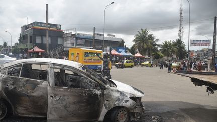 Voiture incendiée lors de manifestations contre un troisième mandat du président ivoirien Alassane Ouattara, dans le quartier de Cocody à Abidjan, la capitale économique de Côte d'Ivoire, le 19 octobre 2020. (SIA KAMBOU / AFP)