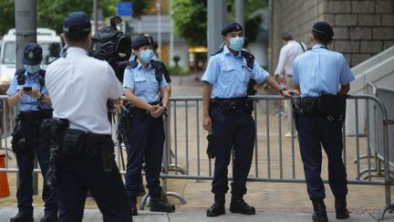 Des policiers devant un tribunal&nbsp;de Hong Kong pour le procès de Tong Ying-Kit,&nbsp;première personne jugée&nbsp;pour non-respect de la loi sur la sécurité nationale, le 23 juin 2021.&nbsp; (VINCENT YU / AP / SIPA)