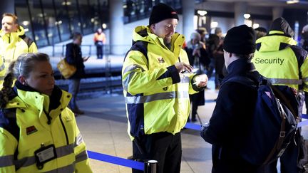 Le personnel de sécurité effectue des contrôles à&nbsp;l'aéroport de Kastrup, près&nbsp;de Copenhague (Danemark), pour les voyageurs se rendant en Suède. (BJORN LINDGREN / TT NEWS AGENCY / AFP)