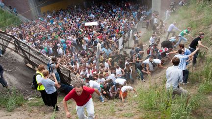 Un mouvement de panique saisit la foule lors de la Loveparade de Duisburg, dans l'ouest de l'Allemagne, le 24 juillet 2010. Vingt et une personnes sont mortes lors de cette bousculade. (ERIK WIFFERS / DPA / AFP)