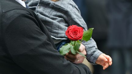 Un homme tient une rose à la main, devant le siège du PS, le 14 mai 2017. (ISA HARSIN / SIPA)