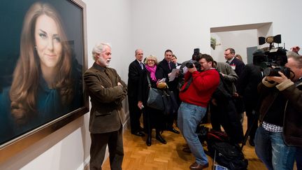 Paul Emsley pose devant son tableau repr&eacute;sentant la duchesse Kate Middleton, le 11 janvier 2013 &agrave; la National Portrait Gallery de Londres (Royaume-Uni).&nbsp; (LEON NEAL / AFP)