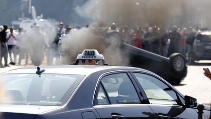 Une voiture d&eacute;pendant du service Uber a &eacute;t&eacute; retourn&eacute;e par des taxis en col&egrave;re, &agrave; Paris, le 25 juin 2015. ( CHARLES PLATIAU / REUTERS)