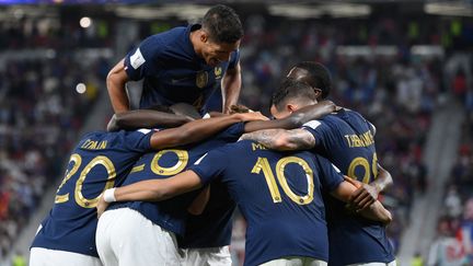 Raphaël Varane au dessus de la mêlée des Bleus, unis dans la joie lors du 8e de finale de la Coupe du monde entre la France et la Pologne, le 4 décembre 2022. (FRANCK FIFE / AFP)