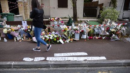 Une passante&nbsp;se recueille devant le domicile de la victime, Chahinez B., brûlée vive par son mari le 4 mai 2021 à Mérignac (Gironde). (STEPHANE DUPRAT / HANS LUCAS)