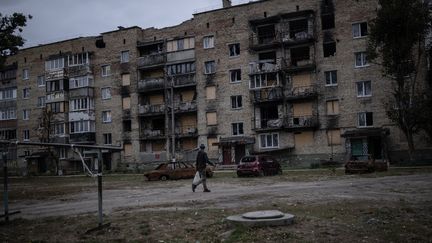 A person walks next to a building damaged by Russia's invasion in kyiv (Ukraine), October 7, 2023. (OZGE ELIF KIZIL / ANADOLU AGENCY / AFP)