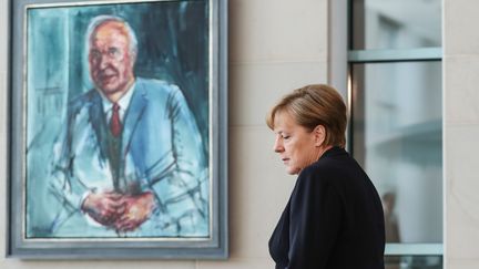 La chancelière allemande Angela Merkel devant un portrait d'Helmut Kohl, le 18 juin, à Berlin. (SHAN YUQI / XINHUA / MAXPPP)