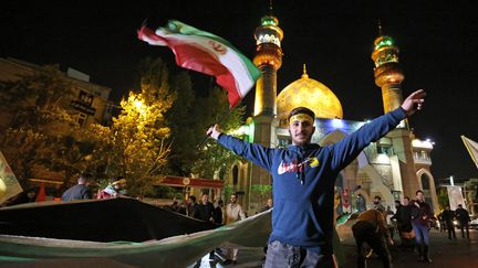 Un Iranien manifeste sa joie sur une place de Téhéran après les frappes contre Israël, le 14 avril 2024 (ATTA KENARE / AFP)