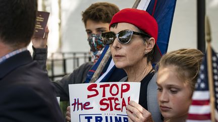 Une femme tient une pancarte de soutien au président américain Donald Trump lors d'une conférence de presse devant le siège du Comité national républicain au Capitole, le 5 novembre 2020 à Washington. (AL DRAGO / GETTY IMAGES NORTH AMERICA)