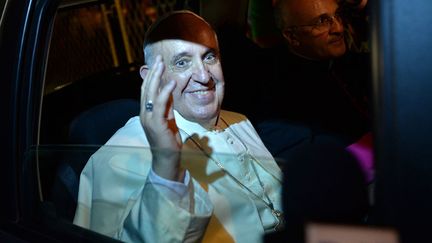 Le pape Fran&ccedil;ois salut depuis sa voiture en quittant le&nbsp;Guanabara Palace, si&egrave;ge du gouvernement br&eacute;silien &agrave; Rio de Janeiro (Br&eacute;sil), le 22 juillet 2013. (YASUYOSHI CHIBA / AFP)