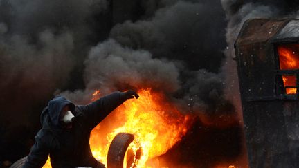 Un homme lance des pierres le 23 janvier 2014, &agrave; Kiev. (VASILY MAXIMOV / AFP)