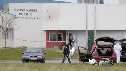 Des policiers ramassent des indices apr&egrave;s l'&eacute;vasion de Redoine Fa&iuml;d, en avril 2013, de la prison de Sequedin (Nord). Un nouveau d&eacute;tenu s'est &eacute;vad&eacute; de l'&eacute;tablissement, le 16 juillet 2013. (FRANCOIS LO PRESTI / AFP)