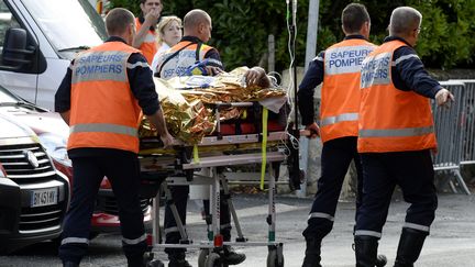 Des secours transportent un bless&eacute; &agrave; Puisseguin (Gironde), le 23 octobre 2015, apr&egrave;s l'accident meurtrier qui s'est produit &agrave; la sortie de la commune. (JEAN-PIERRE MULLER / AFP)