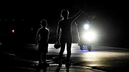 Des habitants pendant une panne d'électricité à Bauta, dans la province d'Artemisia (Cuba), le 18 mars 2024. (YAMIL LAGE / AFP)