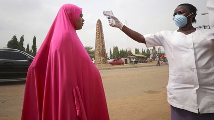 Au Nigeria, les autorités essayent de limiter la propagation du coronavirus en instaurant un contrôle de la température dans les grandes villes du pays. Un quart des Nigérians, qui se définissent comme des "enfants de Dieu", se croient immunisés.&nbsp; &nbsp; (AFOLABI SOTUNDE / REUTERS)