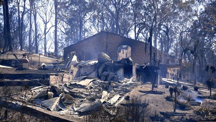 De la fumée s'échappe d'une maison incendiée à&nbsp;Tathra (Australie), le 19 mars 2018. (STRINGER / REUTERS)