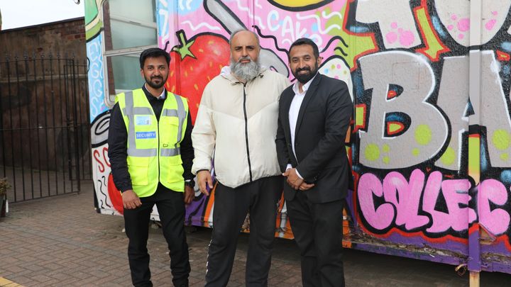 Gohar Ihsan (au centre) devant la banque alimentaire de la mosquée centrale, entouré des agents de sécurité Abdul Salam (à gauche) et Waqas (à droite) à Middlesbrough, en Angleterre, le 12 août 2024. (ELISE LAMBERT / FRANCEINFO)