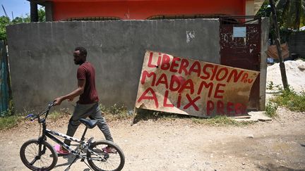 Dans une rue de Port-au-Prince (Haïti), le 3 août 2023, devant une affiche appelant à la libération d'une infirmière américaine et de son enfant kidnappés. (RICHARD PIERRIN / AFP)