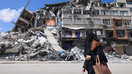 Une femme palestinienne devant un bâtiment détruit, le 22 mai 2021 à Gaza. (EMMANUEL DUNAND / AFP)