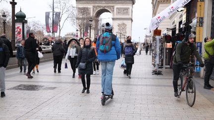 La cohabitation entre piétons, trottinettes et vélos, pas toujours facile sur les trottoirs (illustration sur les Champs-Elysées, à Paris). (OLIVIER BOITET / MAXPPP)