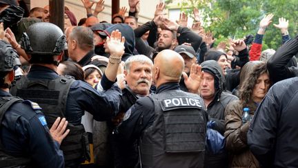 Des Serbes face à la police kosovare à Zvecan (Kosovo), le 26 mai 2023. (STRINGER / AFP)