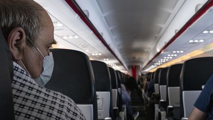 Un passager porte un masque sur un vol Air France au départ d'Athènes (Grèce), le 17 mars 2020. (ANTONI LALLICAN / HANS LUCAS / AFP)