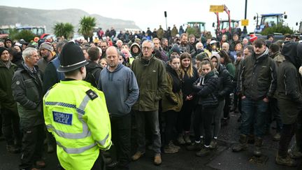 Des agriculteurs britanniques devant un policier, le 16 novembre 2024 à Llandudno (Royaume-Uni). (OLI SCARFF / AFP)