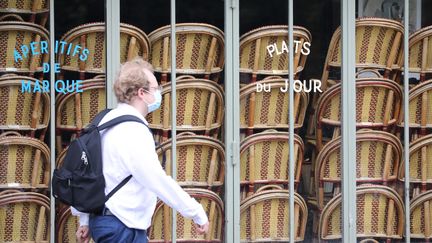 Un homme passe devant un restaurant fermé en raison de la pandémie de Covid-19, le 9 mai 2020 à Paris. (MAXPPP)