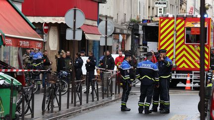 Des agents de sécurité français sécurisent les abords de la rue après plusieurs coups de feu tirés rue d'Enghien dans le 10e arrondissement, à Paris, le 23 décembre 2022. (THOMAS SAMSON / AFP)
